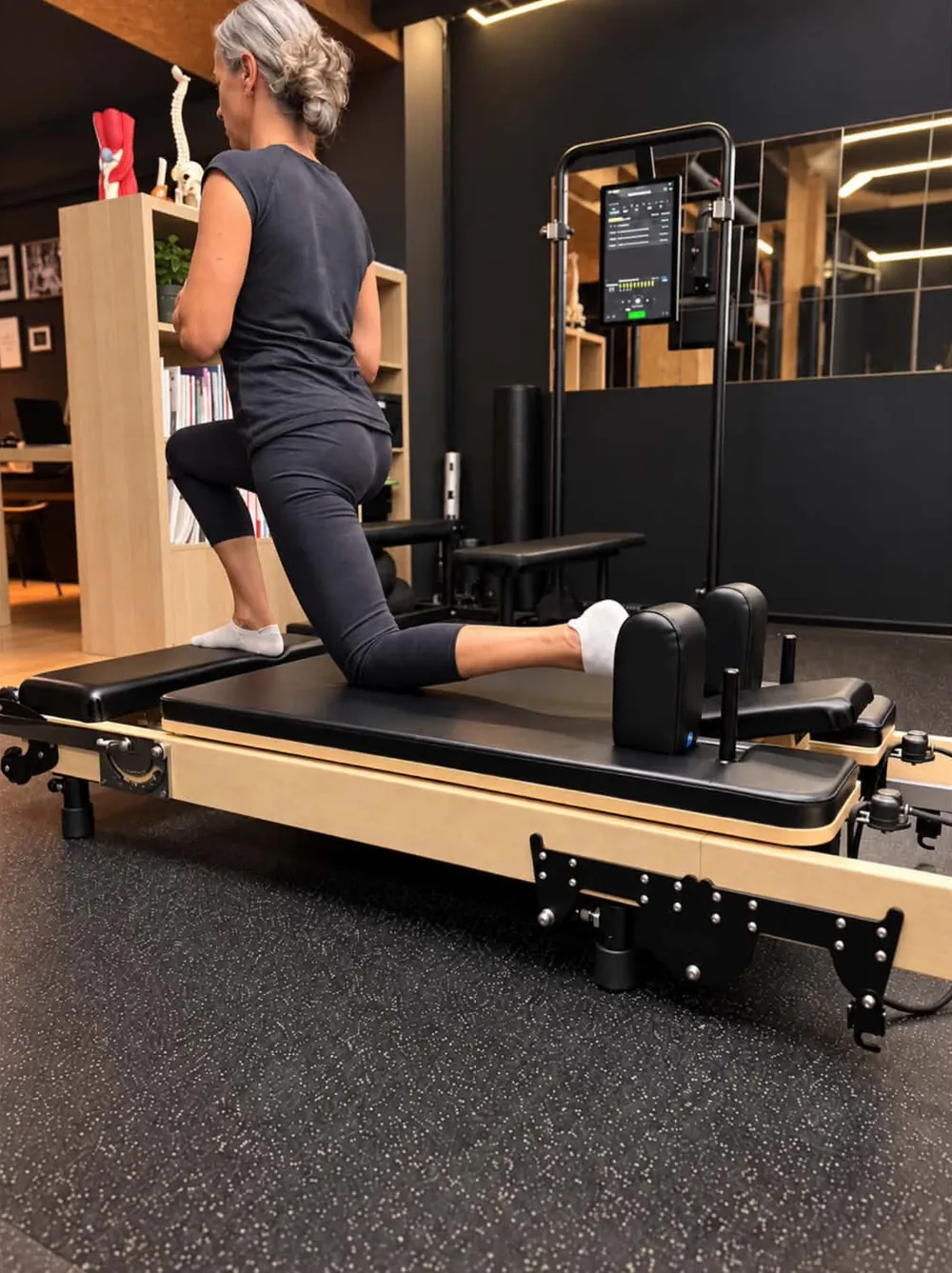Une adhérente en fente sur le chariot du Pilates Reformer, au centre Platinium Training à Toulon